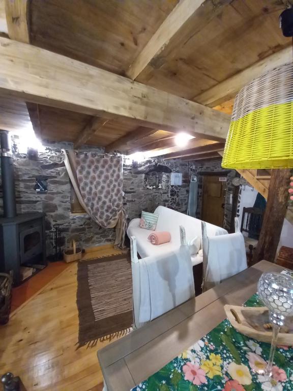 uma sala de estar com um sofá branco e uma mesa em Talasnal Casas da Urze TER em Lousã