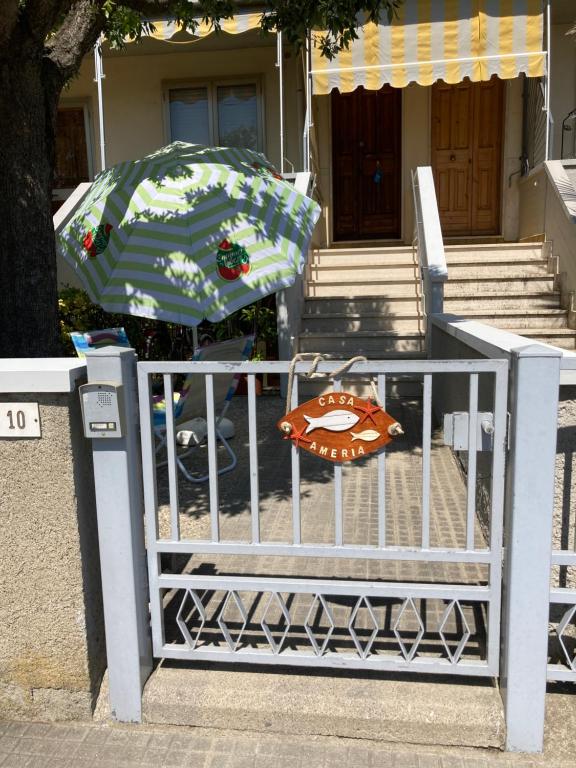 niebiesko-biały parasol siedzący na płocie w obiekcie Casa Ameria w mieście Cecina
