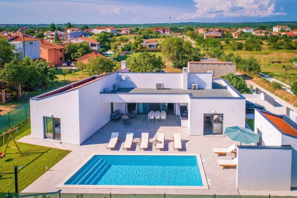 - une vue aérienne sur une villa avec une piscine dans l'établissement Villa Mateo with heated pool, à Fažana