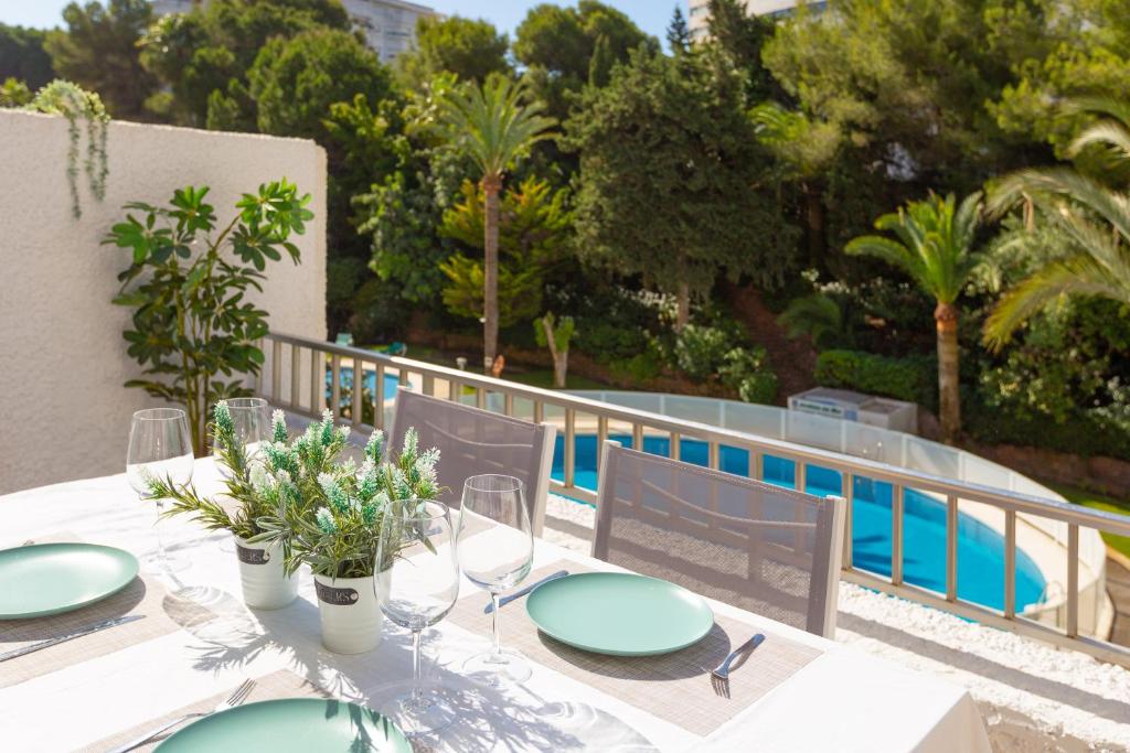 uma mesa com pratos e copos de vinho ao lado de uma piscina em Amazing apartment ,center of Marbella, Beach 338 em Marbella