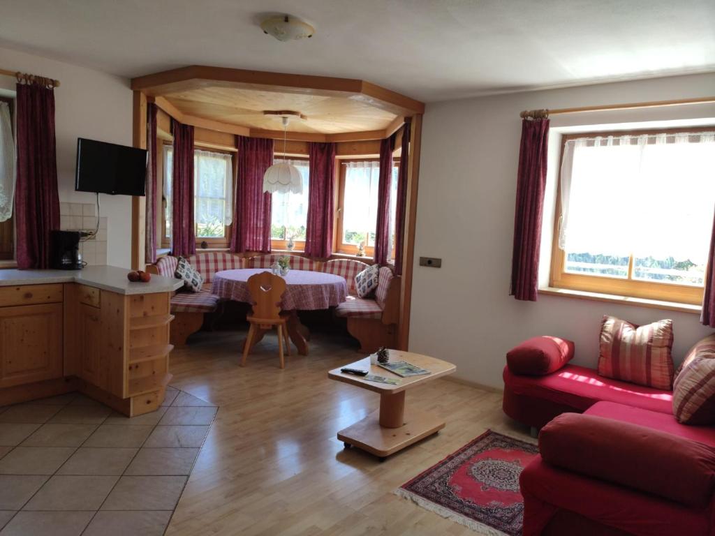 salon z czerwoną kanapą i stołem w obiekcie Obkirchhof w mieście Unsere Liebe Frau im Walde