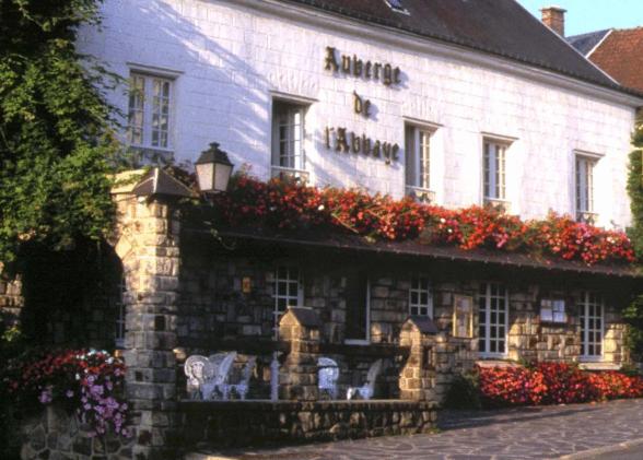 a building with flowers on the side of it at Auberge De L'abbaye in Signy-lʼAbbaye