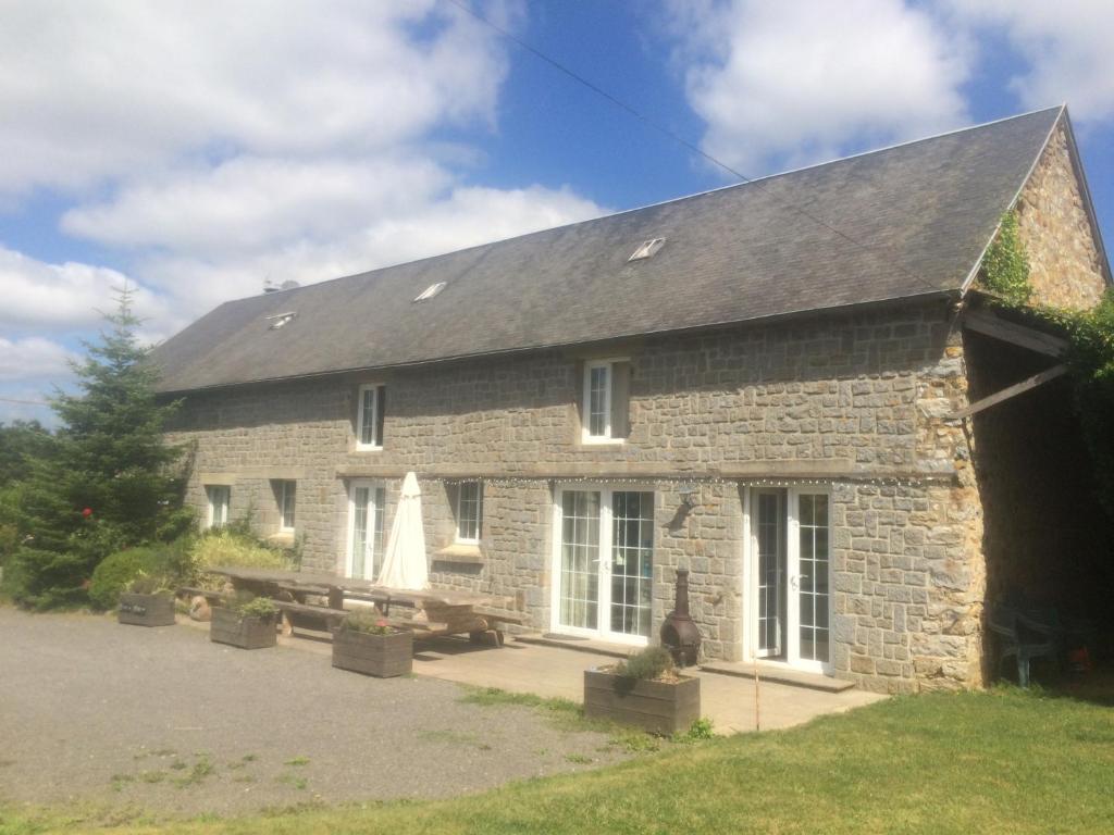 a stone building with a picnic table in front of it at Self Catering for large groups, friends/families in Romagny