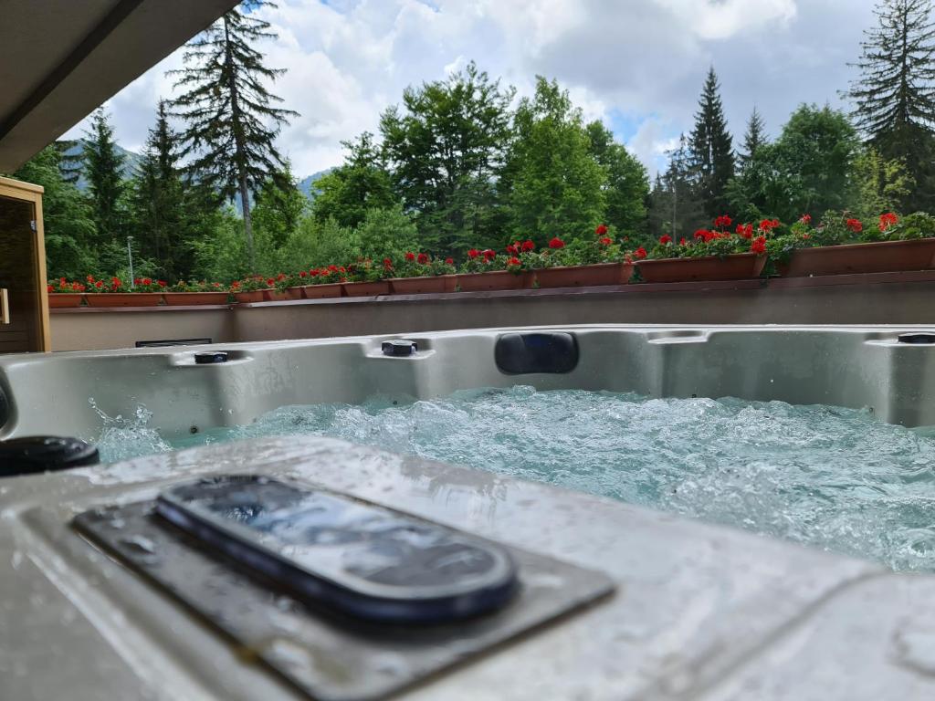 - un téléphone portable dans une baignoire avec de l'eau dans l'établissement Mariah Spa Deluxe Apartment in SILVER MOUNTAIN, à Poiana Brasov