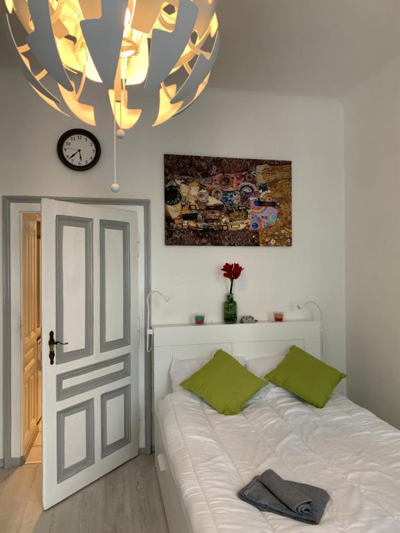 a bedroom with a bed and a clock and a door at centrally & comfortable in Vienna