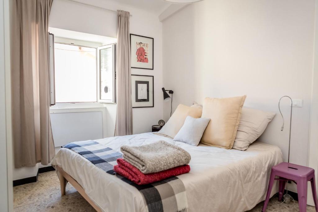 een slaapkamer met een bed met een stapel kussens bij Suite contemporanea tra le vie storiche in Moneglia