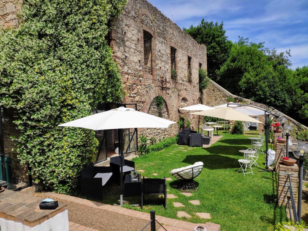科森扎的住宿－Dimora dei marchi b&b，一个带遮阳伞和椅子的花园以及一座建筑
