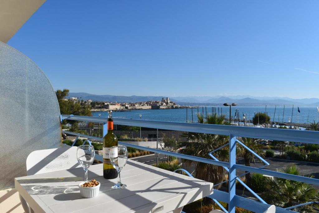 Luxury Seaview Residence Belvedere, Apt A في أنتيب: طاولة مع كؤوس للنبيذ وإطلالة على المحيط