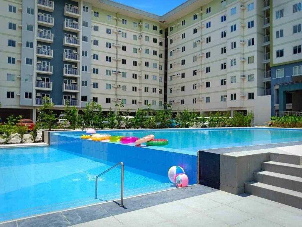 a swimming pool in front of a large building at Calm & Cozy Hideaway in Tunkong Manga