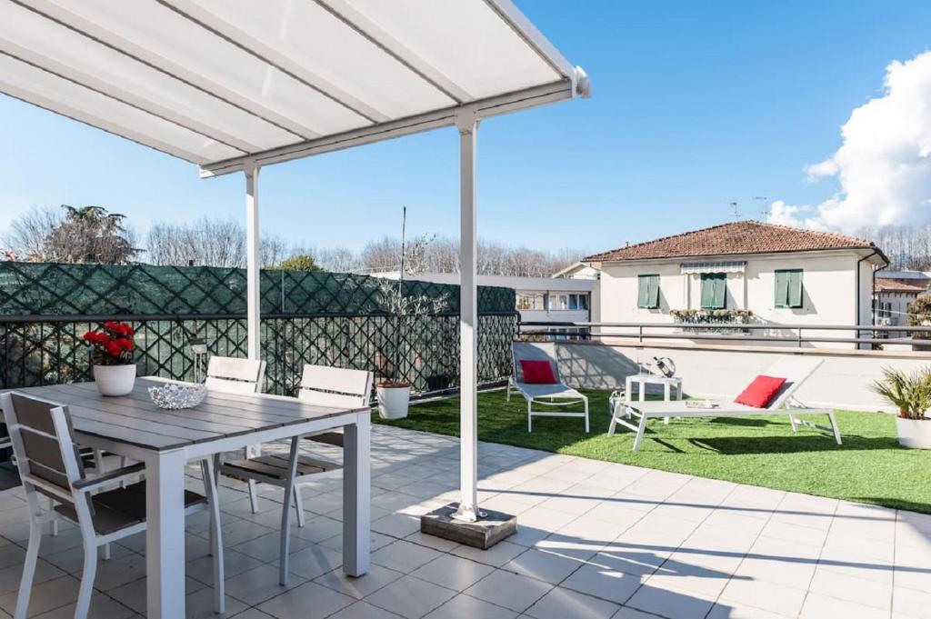 eine weiße Pergola auf einer Terrasse mit einem Tisch und Stühlen in der Unterkunft Sun Terrace Appartment in Lucca