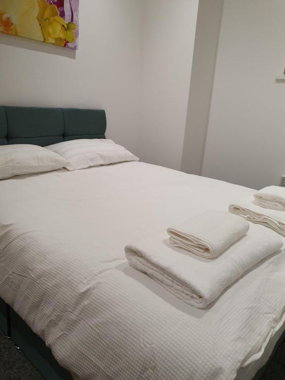 a bed with white blankets and towels on it at Heart of YORK in York