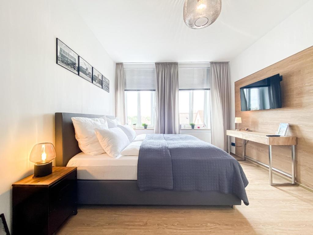 1 dormitorio con 1 cama, escritorio y ventana en Luxus-Apartment in Leipzig mit Privat-Parkplatz, en Leipzig