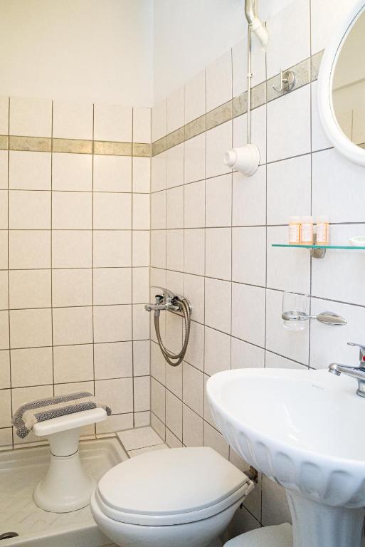 łazienka z toaletą i umywalką w obiekcie Hôtel Argo w mieście Wolos