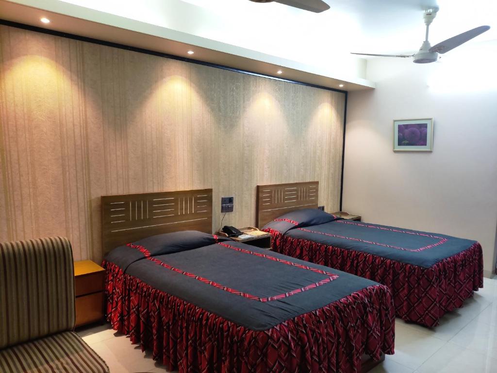a bedroom with two beds and a couch at Asian SR Hotel in Chittagong