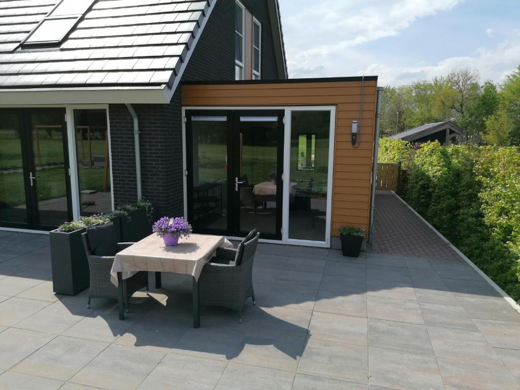 eine Terrasse mit einem Tisch und Stühlen vor einem Haus in der Unterkunft B&B Speulderveld in Ermelo