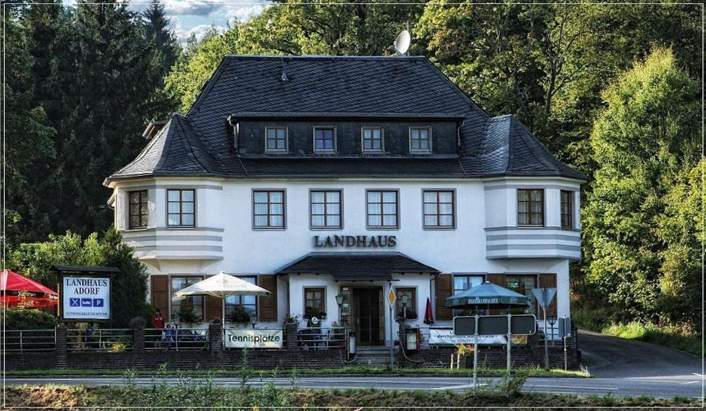 un grande edificio bianco con un cartello di fronte di Landhaus Adorf a Bad Elster