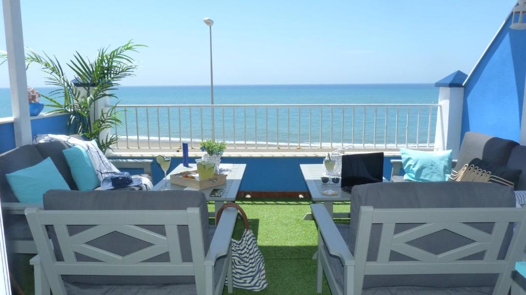 balcón con mesa, sillas y vistas al océano en La Casa De La Playa en Chilches