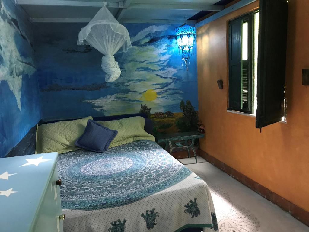 a bedroom with a bed with a painting on the wall at Estância Verde in Valença