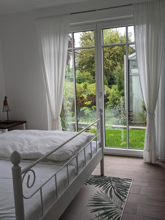 a bedroom with a bed and a large window at Haus zur Aach in Uhldingen-Mühlhofen