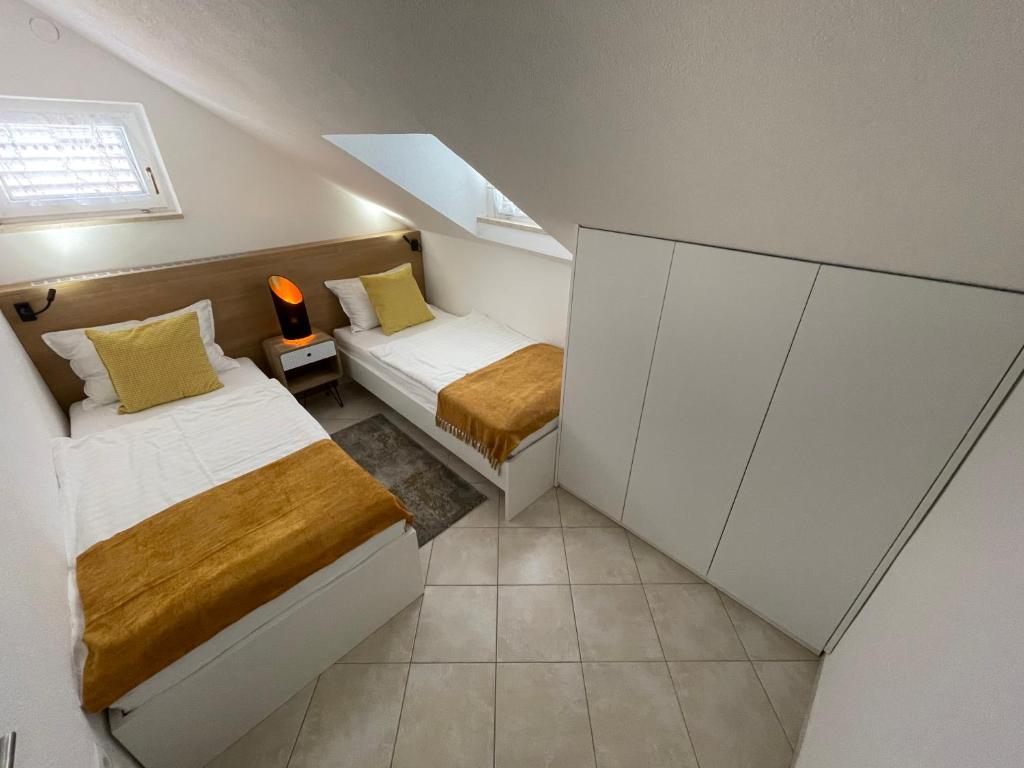 mała sypialnia z dwoma łóżkami i oknem w obiekcie Holiday Home "Mala kuća " with heated pool w Puli
