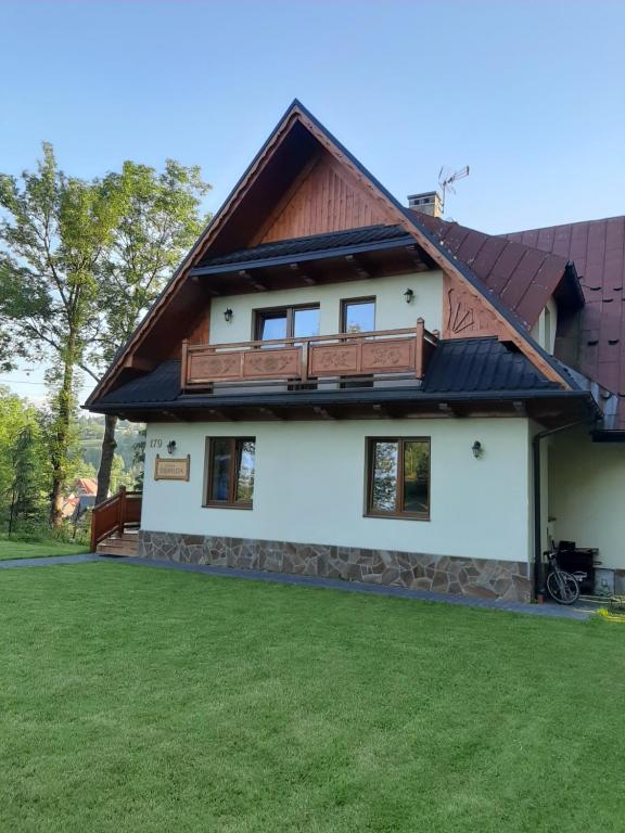 a white house with a brown roof at WILLA TOMIDA in Jurgów