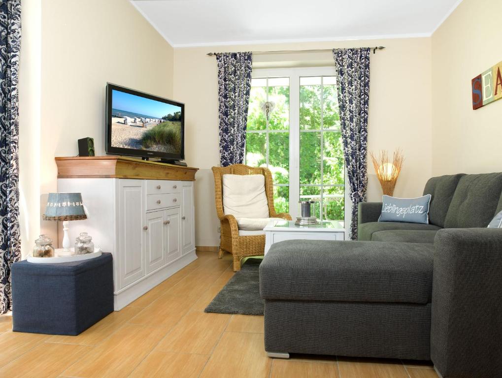 een woonkamer met een bank en een tv bij Gollwitzer Park Oase in Insel Poel