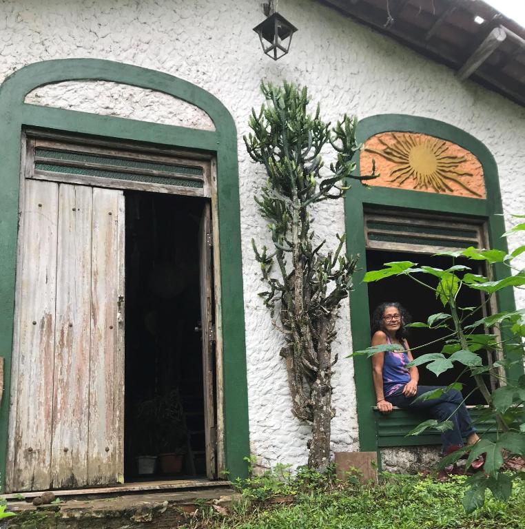 a woman sitting in a window of a house at Estância Verde in Valença