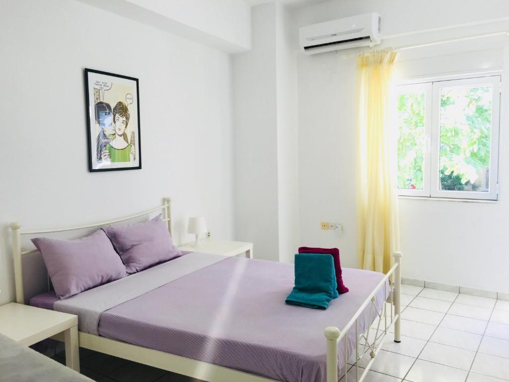 um quarto branco com uma cama e uma janela em Korona beach apartments III em Rethymno Town