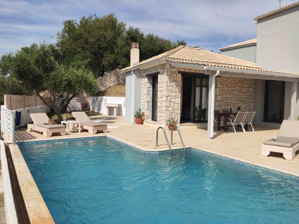 a swimming pool in front of a house at Villa Zante Avia in Planos