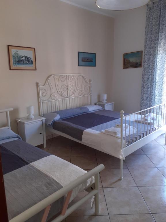 - une chambre avec 2 lits et 2 tables de chevet dans l'établissement Nonnacettyhouse, à Torre del Greco