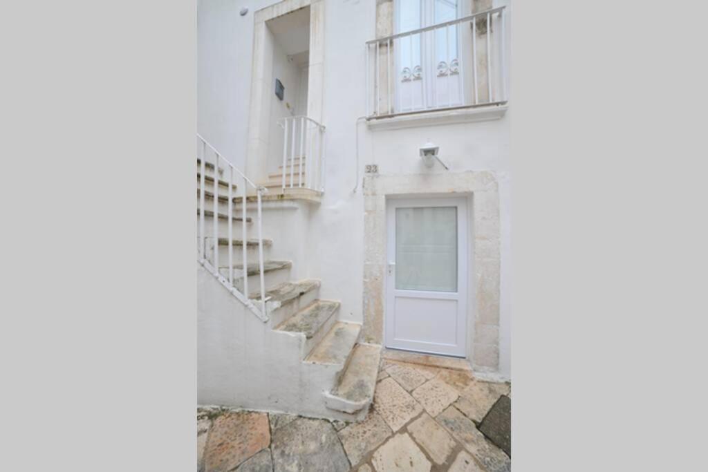 biały budynek ze schodami i drzwiami w obiekcie GaDa Home -centro storico - w mieście Martina Franca