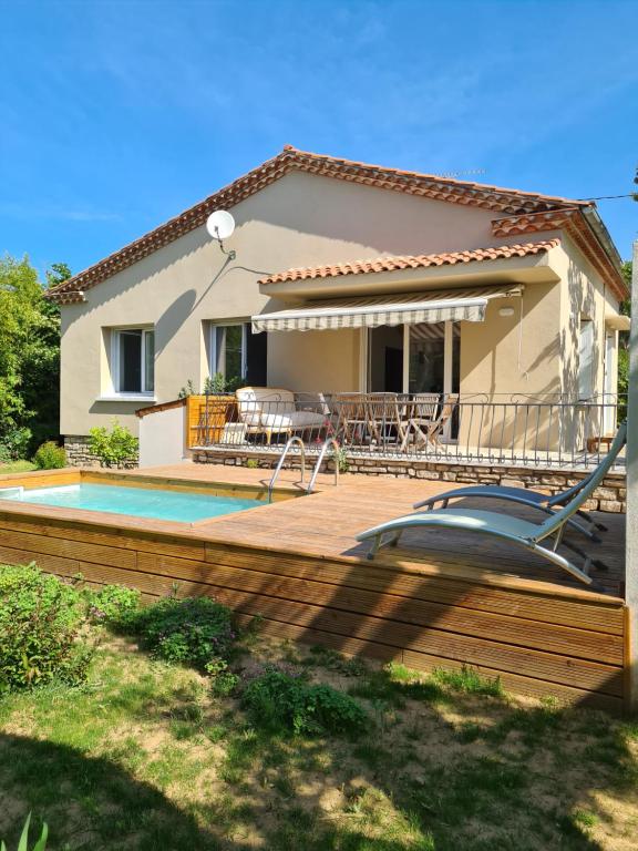 une maison avec une terrasse et une piscine dans l'établissement Villa Caramel, à Saint-Quentin-la-Poterie