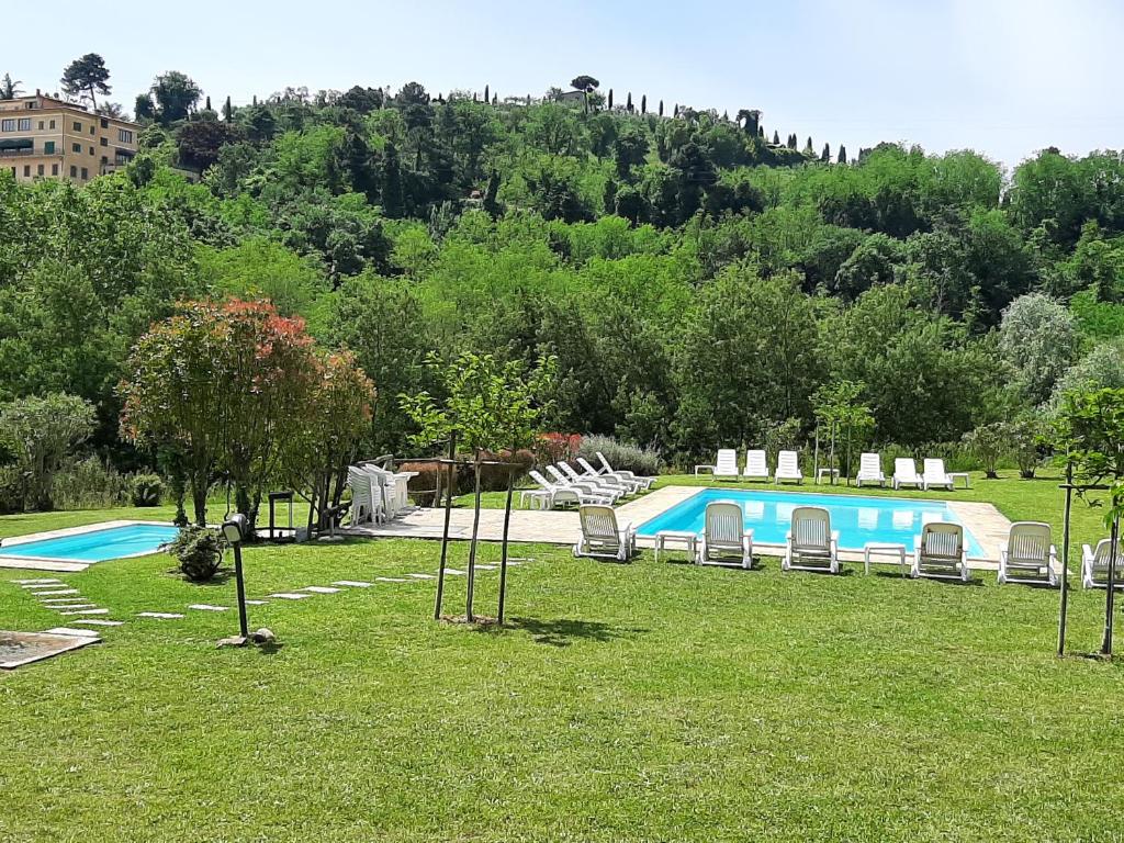 einen Pool mit Liegestühlen in einem Park in der Unterkunft Tenuta degli Obizzi in Montecarlo