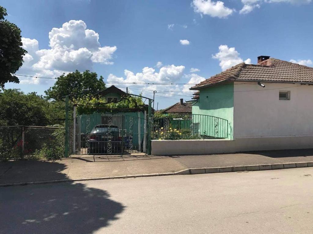 a house with a green fence and a car in it at слънце in Shabla