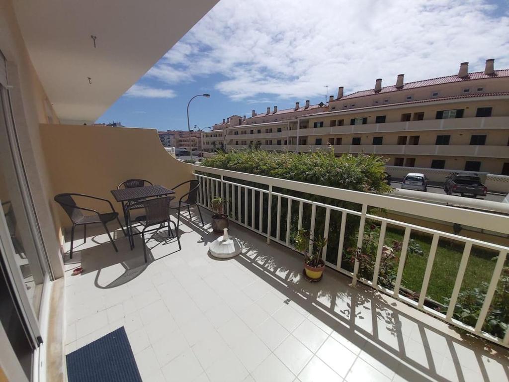 a balcony with a table and chairs and a building at Sunset Village Apartment - Brisa Da Ericeira in Ericeira