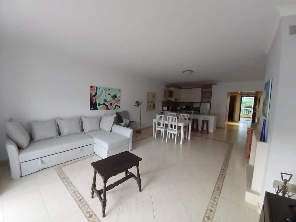 a living room with a white couch and a table at Sunset Village Apartment - Brisa Da Ericeira in Ericeira