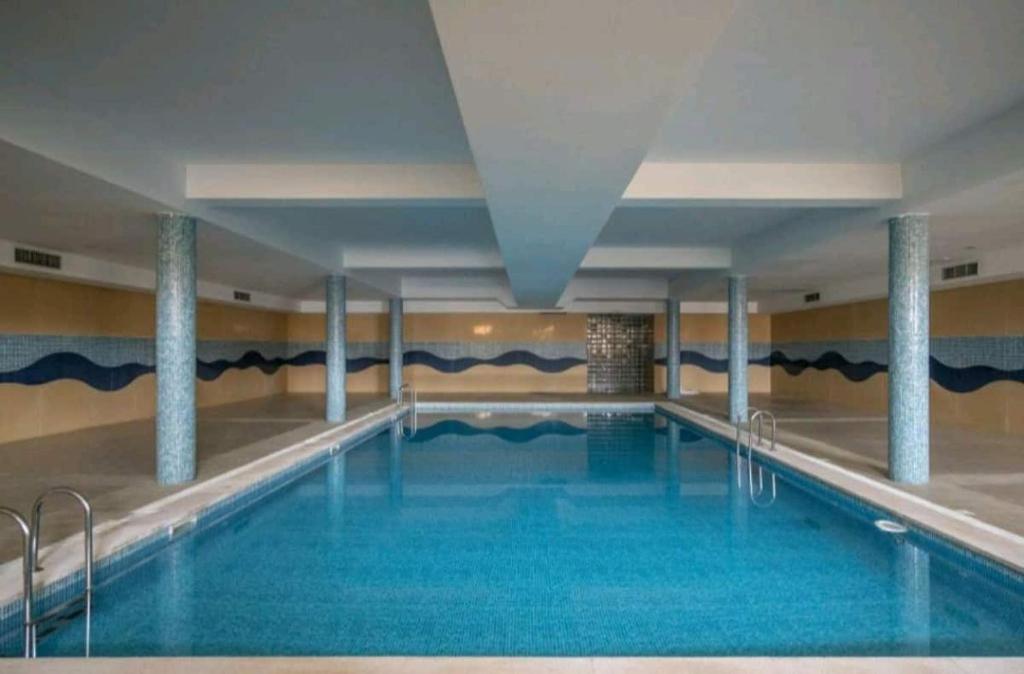 a swimming pool with blue water in a building at Sunset Village Apartment - Brisa Da Ericeira in Ericeira