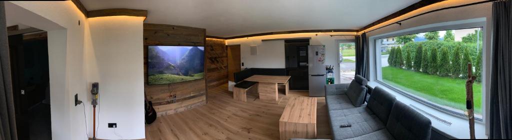 ein Wohnzimmer mit Blick auf ein Haus mit einem Fenster in der Unterkunft Kitz Kaiser Appartement in Sankt Johann in Tirol
