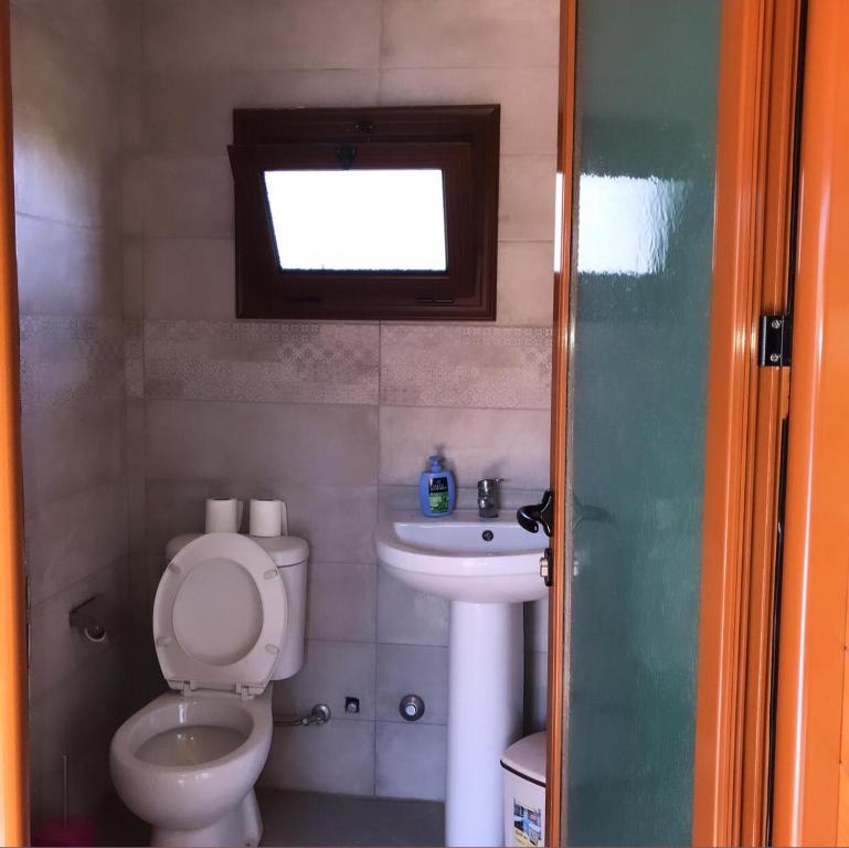 a small bathroom with a toilet and a sink at Violet Village in Borsh