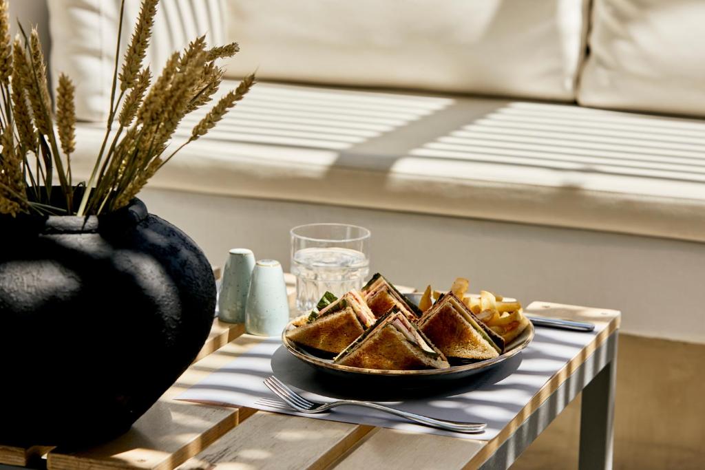a table with a plate of toast on a table at Kouros Village Hotel - Adults Only in Perissa