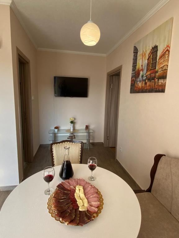 een tafel met wijnglazen en een bord eten erop bij Apartment Lorena in Kotor
