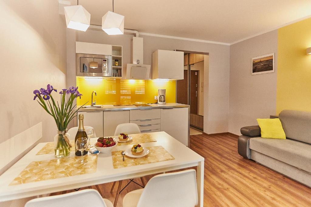 a kitchen and living room with a table and chairs at Apartament Słoneczny in Świnoujście