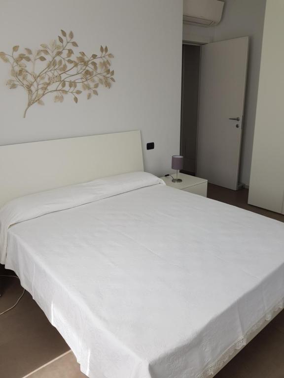 een groot wit bed in een witte kamer bij Appartamento ROSY in Peschiera del Garda