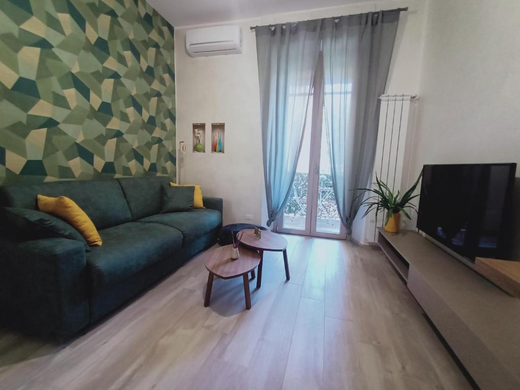 a living room with a green couch and a television at Come a Casa Pretty Apartment in Lido di Ostia