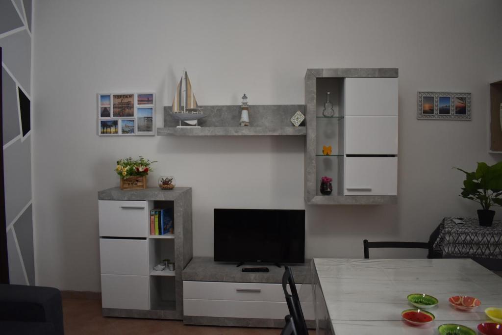 a living room with a table and a tv in a room at Zeropassidalcentro Zeroinfrominthecenter in Marsala