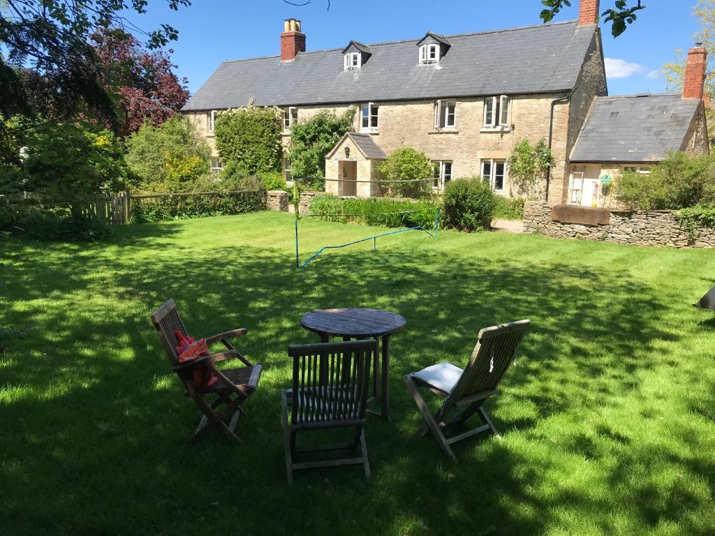 una mesa y sillas en el patio de una casa en The Long House, en Cirencester