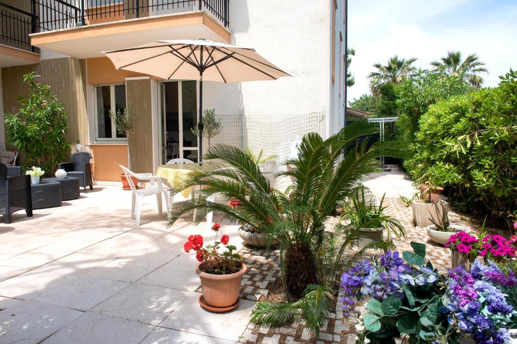 a patio with an umbrella and some plants and flowers at M299 - Marcelli, trilocale a 200 metri dalla spiaggia in Marcelli