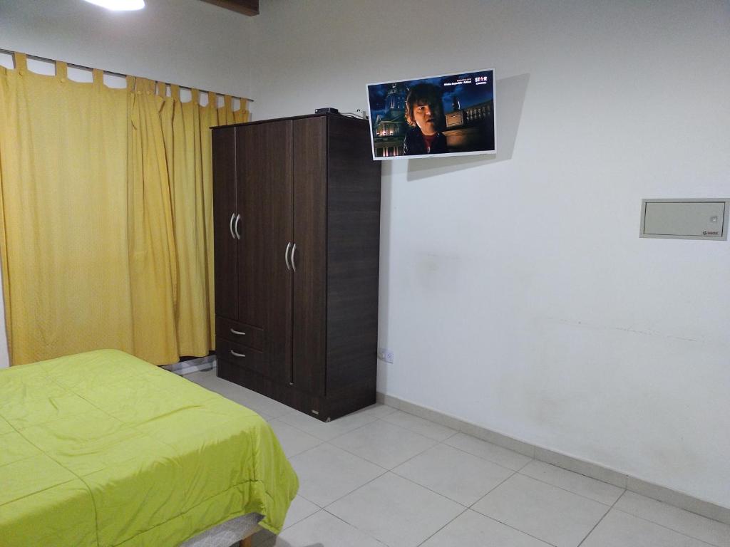 a bedroom with a bed and a tv on a wall at Departamento Monoambiente Rivadavia in San Juan