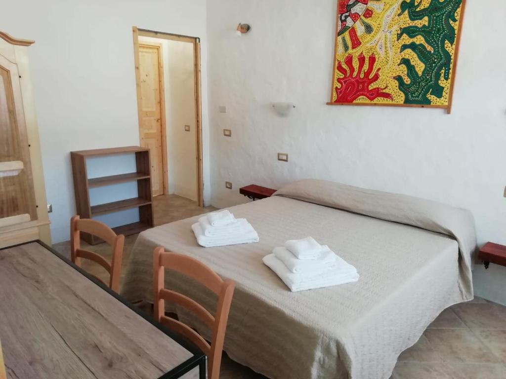 una camera con un letto con due asciugamani di Beni Benìus a Teulada