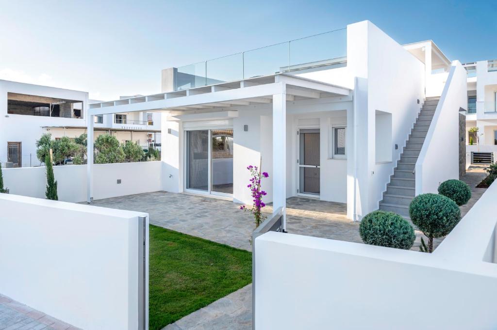 a rendering of a white house with a courtyard at Makrygialos Long Beach Villa 1 in Makry Gialos